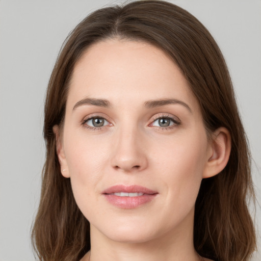 Joyful white young-adult female with long  brown hair and grey eyes