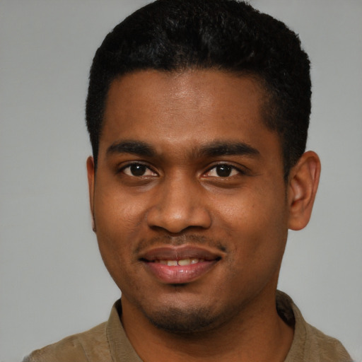 Joyful black young-adult male with short  black hair and brown eyes