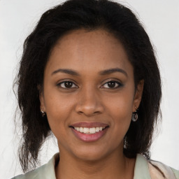 Joyful black young-adult female with long  brown hair and brown eyes