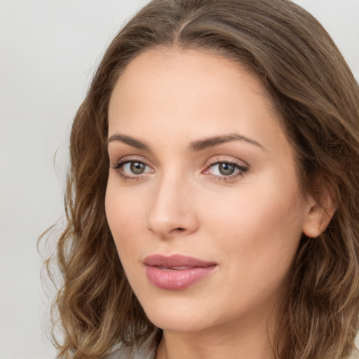 Joyful white young-adult female with long  brown hair and green eyes