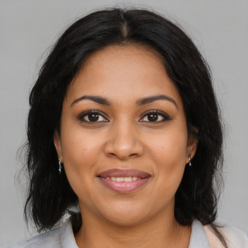 Joyful latino young-adult female with medium  brown hair and brown eyes
