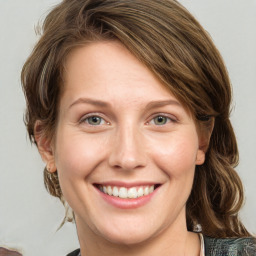 Joyful white young-adult female with medium  brown hair and green eyes