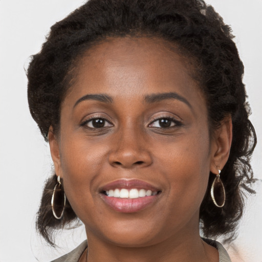 Joyful black young-adult female with long  brown hair and brown eyes