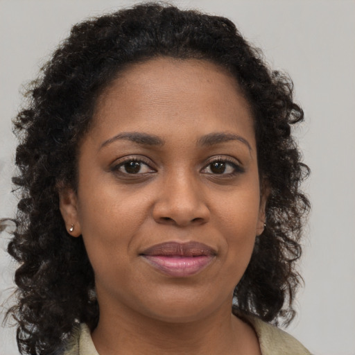 Joyful black young-adult female with long  brown hair and brown eyes