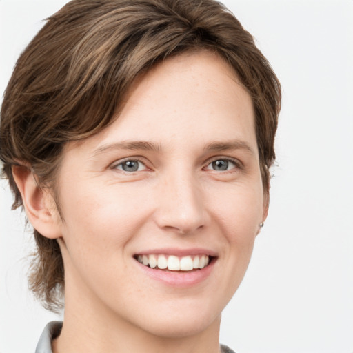 Joyful white young-adult female with short  brown hair and grey eyes