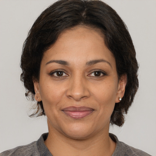 Joyful latino adult female with medium  brown hair and brown eyes