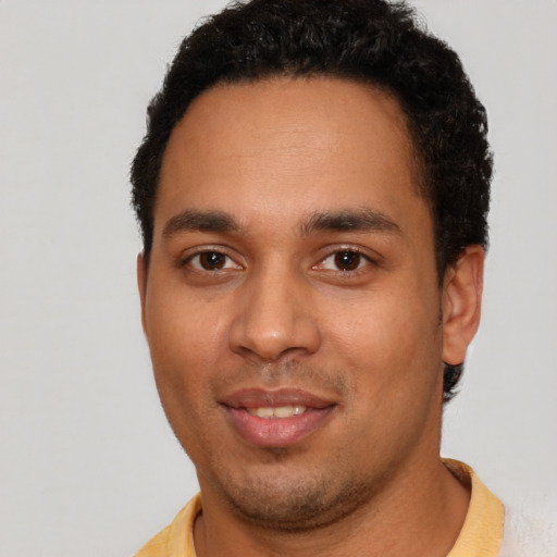 Joyful latino young-adult male with short  brown hair and brown eyes