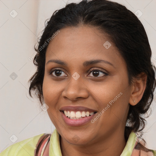 Joyful black young-adult female with medium  brown hair and brown eyes