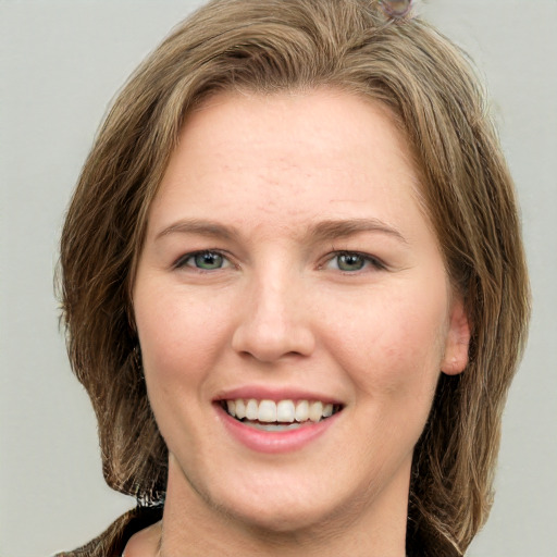 Joyful white young-adult female with long  brown hair and green eyes