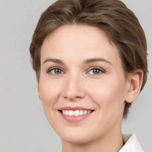 Joyful white young-adult female with short  brown hair and grey eyes