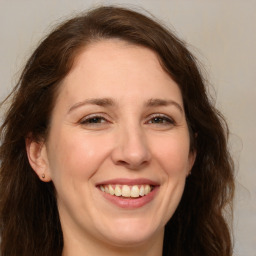 Joyful white adult female with long  brown hair and brown eyes