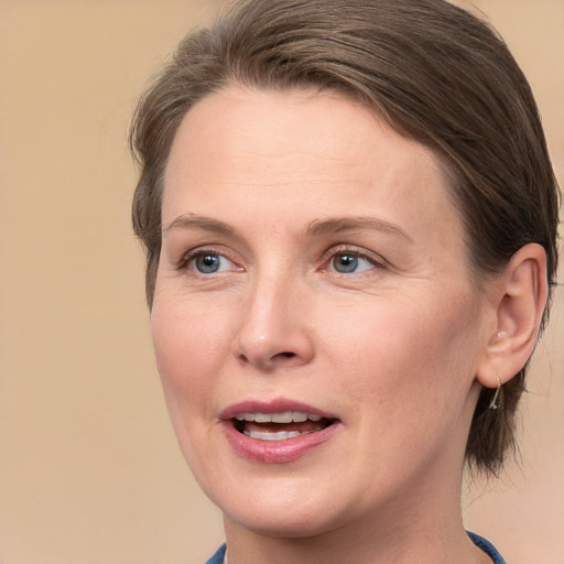 Joyful white adult female with medium  brown hair and grey eyes