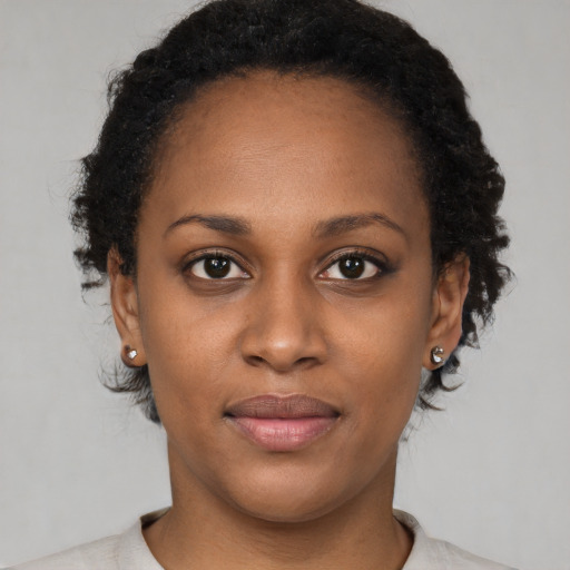 Joyful black young-adult female with short  brown hair and brown eyes