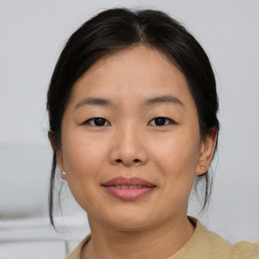 Joyful asian young-adult female with short  brown hair and brown eyes