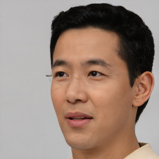 Joyful asian young-adult male with short  black hair and brown eyes