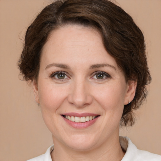 Joyful white adult female with medium  brown hair and green eyes