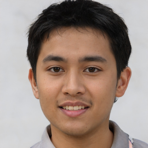 Joyful asian young-adult male with short  brown hair and brown eyes