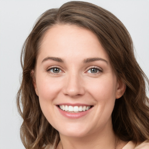 Joyful white young-adult female with long  brown hair and grey eyes