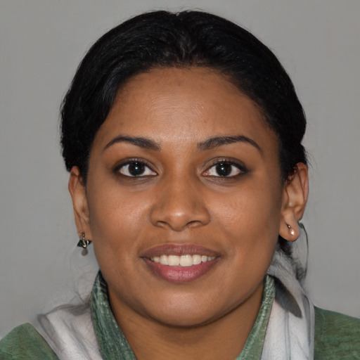 Joyful black young-adult female with medium  black hair and brown eyes