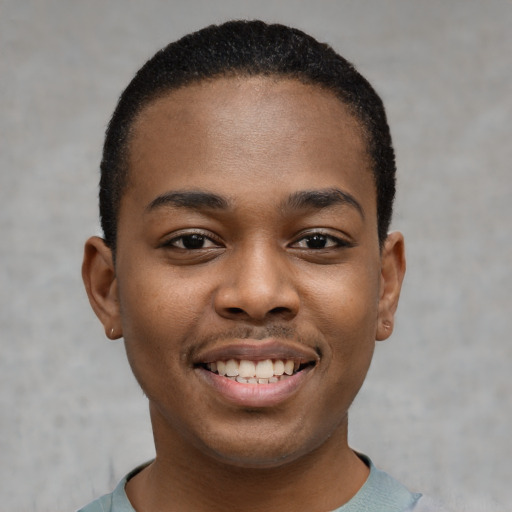 Joyful black young-adult male with short  black hair and brown eyes