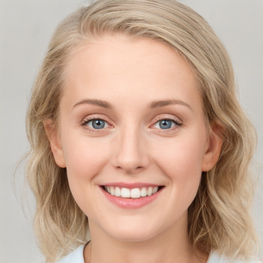 Joyful white young-adult female with medium  brown hair and blue eyes