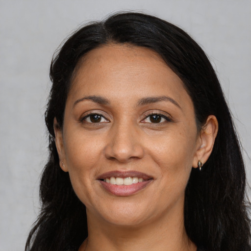 Joyful latino adult female with long  brown hair and brown eyes