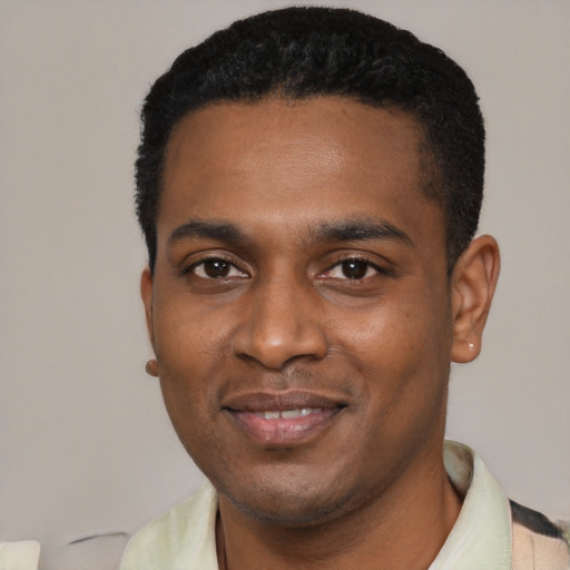 Joyful black young-adult male with short  black hair and brown eyes
