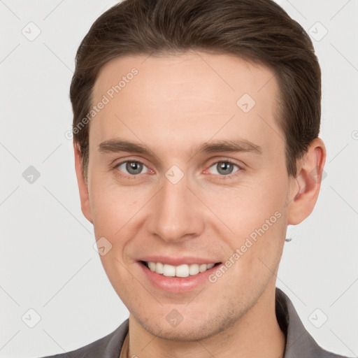 Joyful white young-adult male with short  brown hair and grey eyes