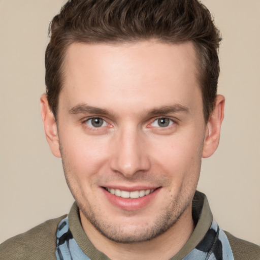 Joyful white young-adult male with short  brown hair and grey eyes