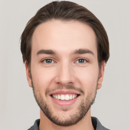 Joyful white young-adult male with short  brown hair and grey eyes