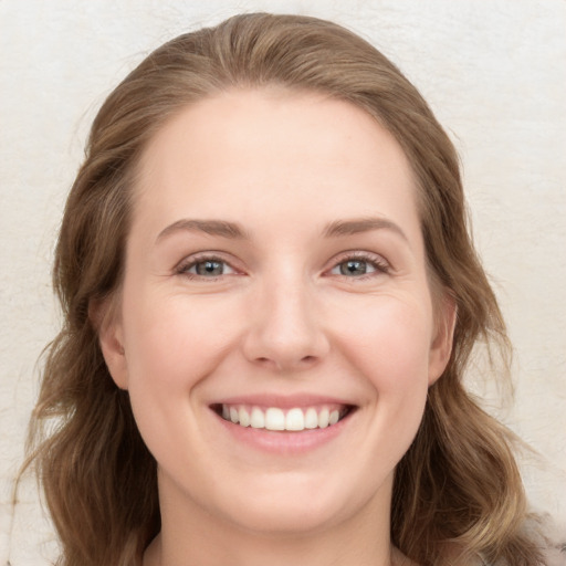 Joyful white young-adult female with long  brown hair and blue eyes