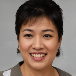 Joyful asian young-adult female with short  brown hair and brown eyes