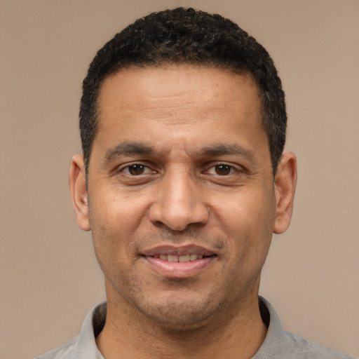 Joyful latino adult male with short  black hair and brown eyes