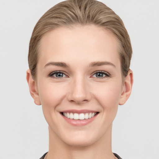 Joyful white young-adult female with short  brown hair and grey eyes