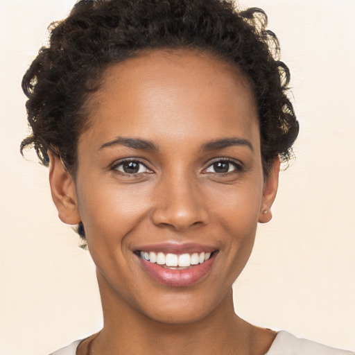 Joyful black young-adult female with short  brown hair and brown eyes