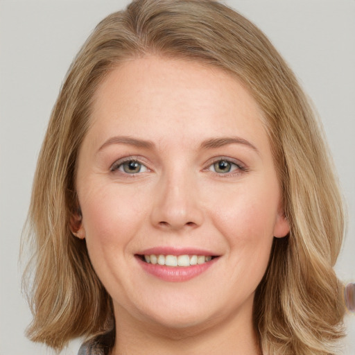 Joyful white young-adult female with long  brown hair and blue eyes