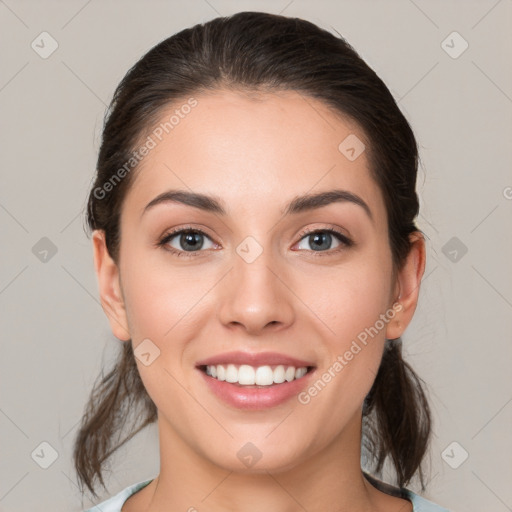 Joyful white young-adult female with medium  brown hair and grey eyes