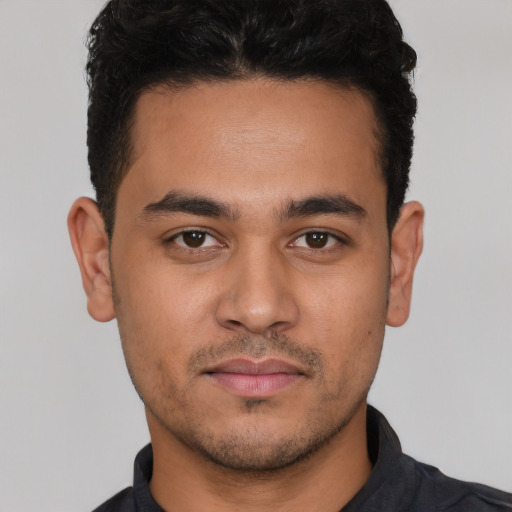 Joyful white young-adult male with short  black hair and brown eyes