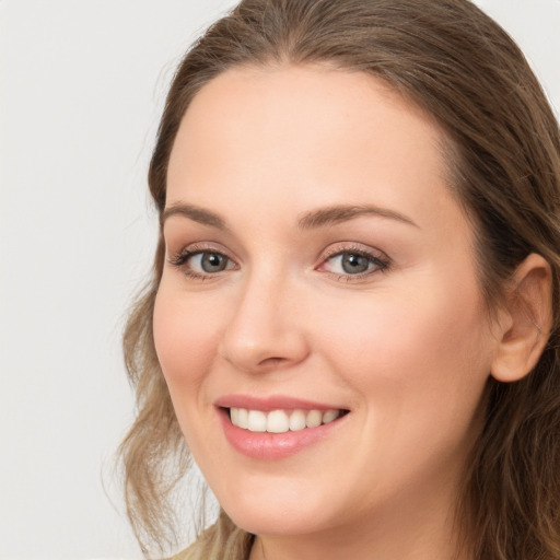 Joyful white young-adult female with long  brown hair and grey eyes