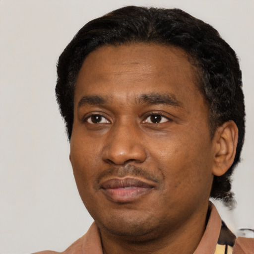 Joyful black adult male with short  black hair and brown eyes