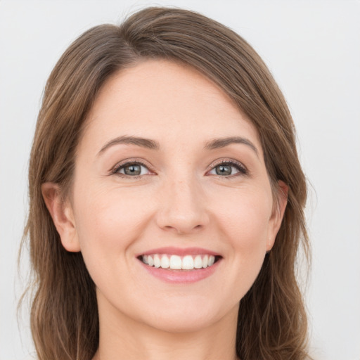 Joyful white young-adult female with long  brown hair and green eyes