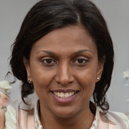 Joyful white adult female with medium  brown hair and brown eyes