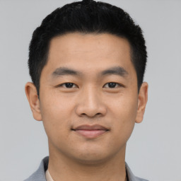 Joyful asian young-adult male with short  black hair and brown eyes