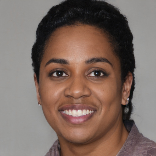 Joyful black young-adult female with short  black hair and brown eyes