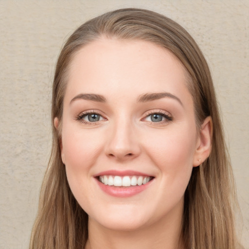 Joyful white young-adult female with long  brown hair and blue eyes