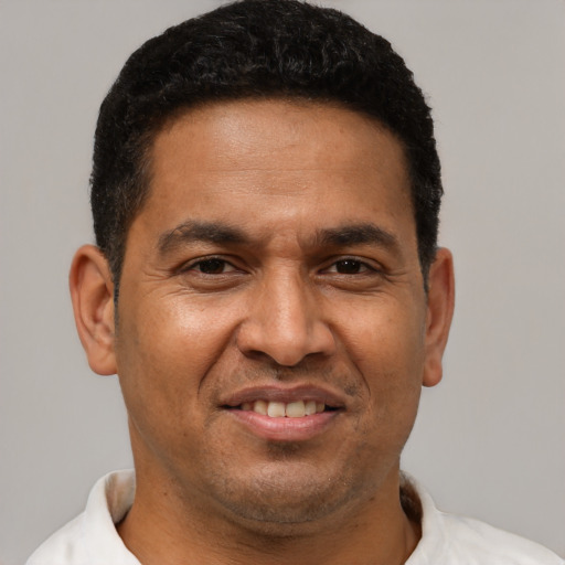 Joyful latino adult male with short  brown hair and brown eyes