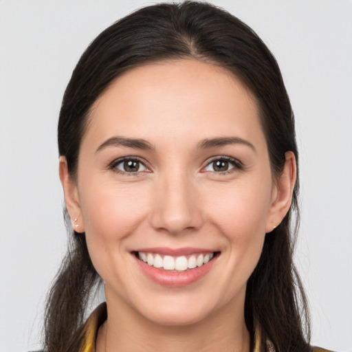 Joyful white young-adult female with long  brown hair and brown eyes