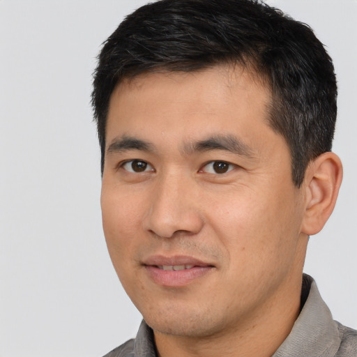 Joyful asian young-adult male with short  black hair and brown eyes