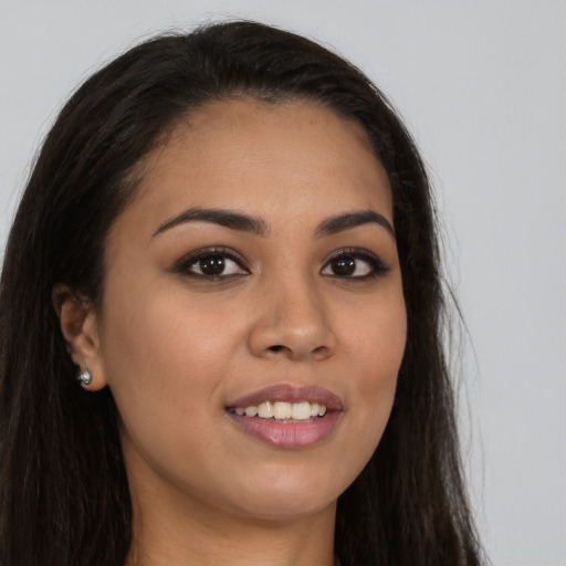 Joyful latino young-adult female with long  brown hair and brown eyes