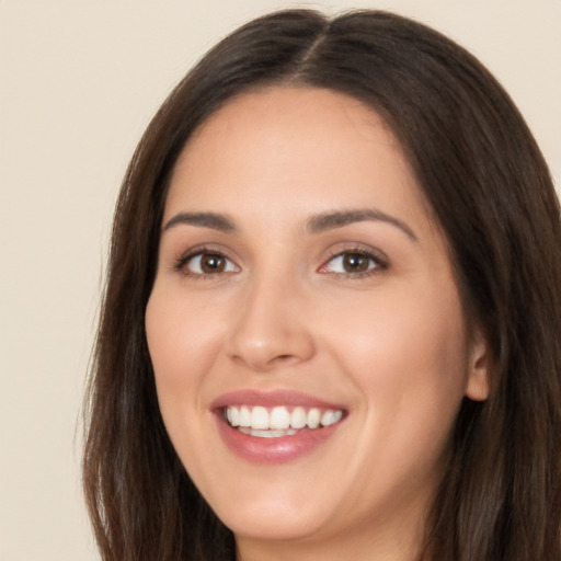 Joyful white young-adult female with long  brown hair and brown eyes